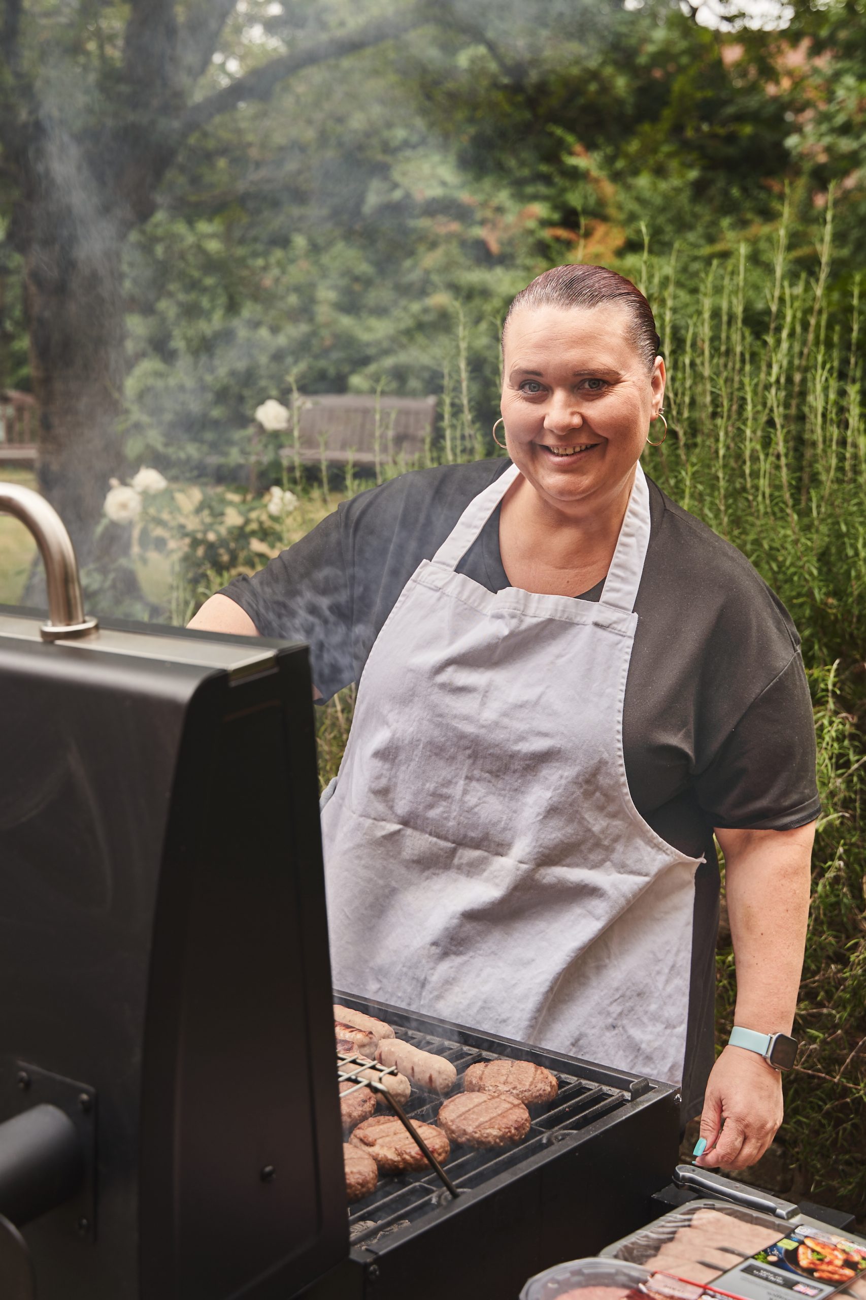 Woman standing at BBQ looking at the camera