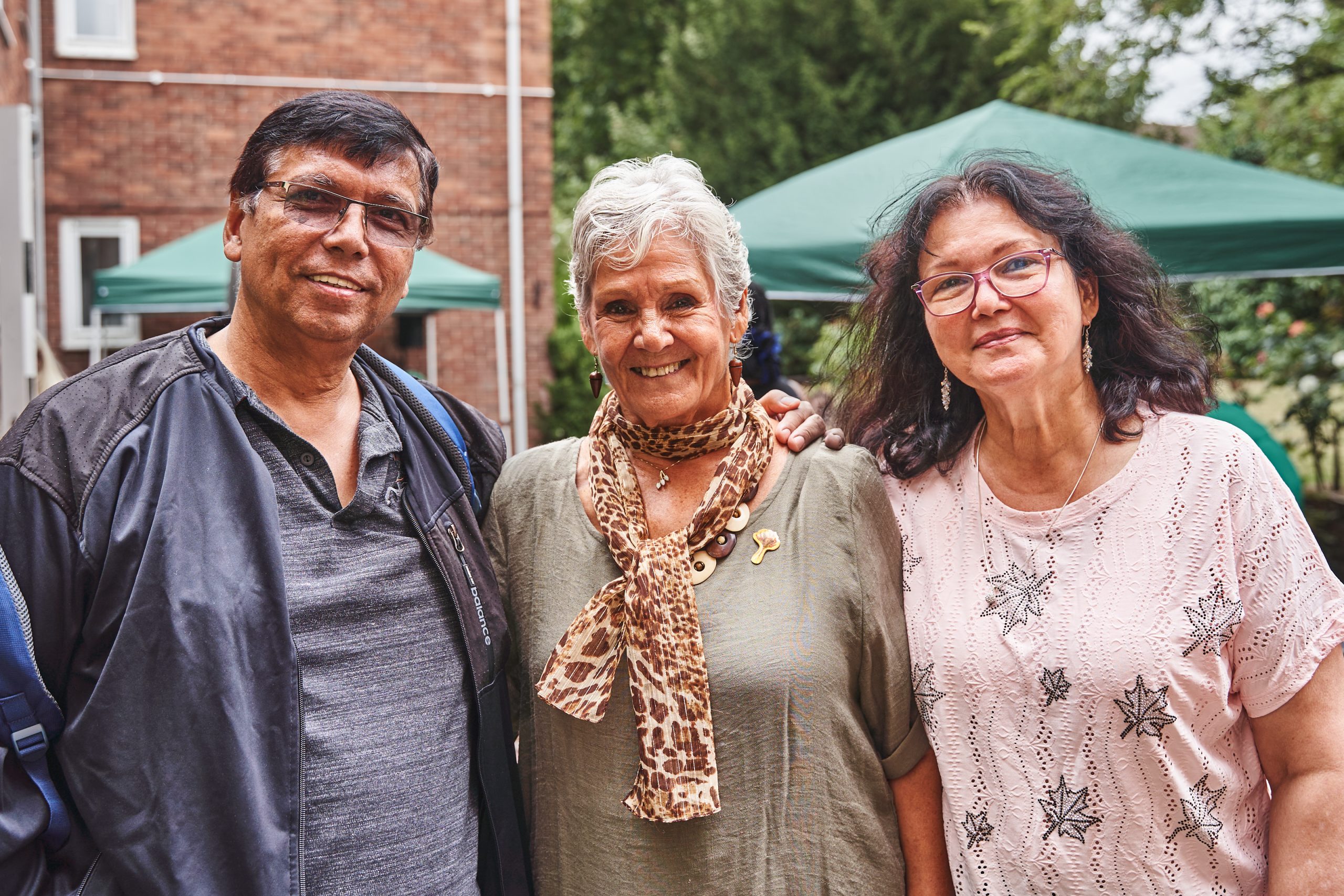 Two women and one man standing side by side smiling to the camera